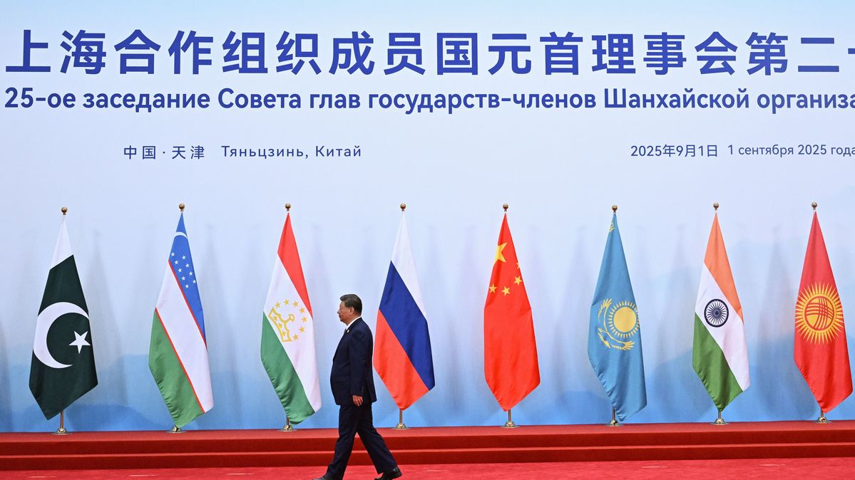 Xi Jinping, President of China, arrives for a meeting of the Shanghai Cooperation Organisation. The President of China walks along a wall with flags.