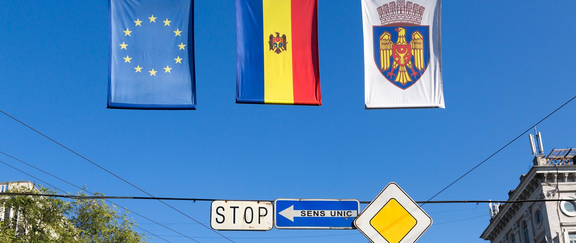 The flag of the Republic of Moldova, the EU flag and a flag with the Chisinau city coat of arms next to each other on Moldova's Independence Day.