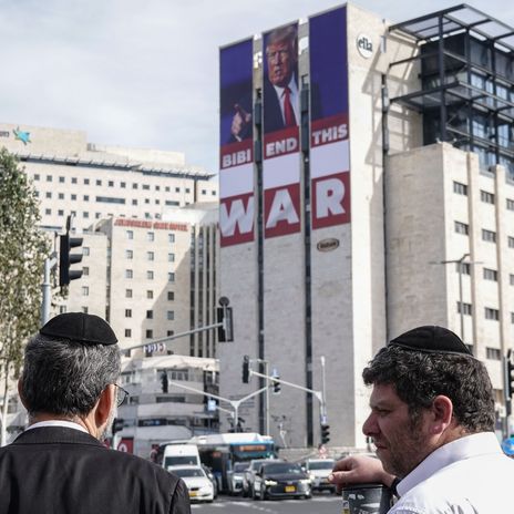 Ein Banner an einem Gebäude in Jerusalem zeigt Donald Trump. Im Schriftzug darunter wird Benjamin Netanjahu aufgefordert den Krieg zu beenden.