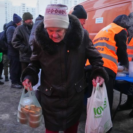 Kyjiw, 2. Februar 2026: Eine Frau bekommt warmes Essen aus einer Ausgabestelle nach russischen Luftangriffen auf das Stromnetz in der Ukraine.