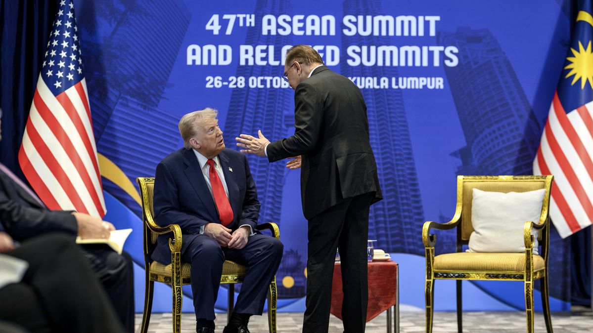 U.S. President Donald Trump and Malaysian Prime Minister Anwar Ibrahim at the ASEAN Summit in Kuala Lumpur U.S. President Donald Trump sits and talks to Malaysian Prime Minister Anwar Ibrahim, standing in front of him