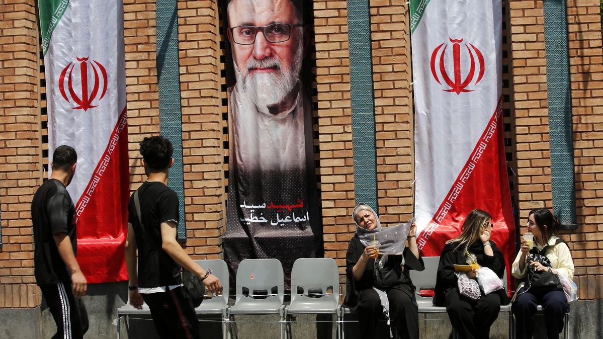 Menschen in Teheran gehen während der Waffenruhe nach den US- und israelischen Angriffen wieder ihrem Alltag nach. Fünf Menschen vor einem Banner von Ali Chamenei