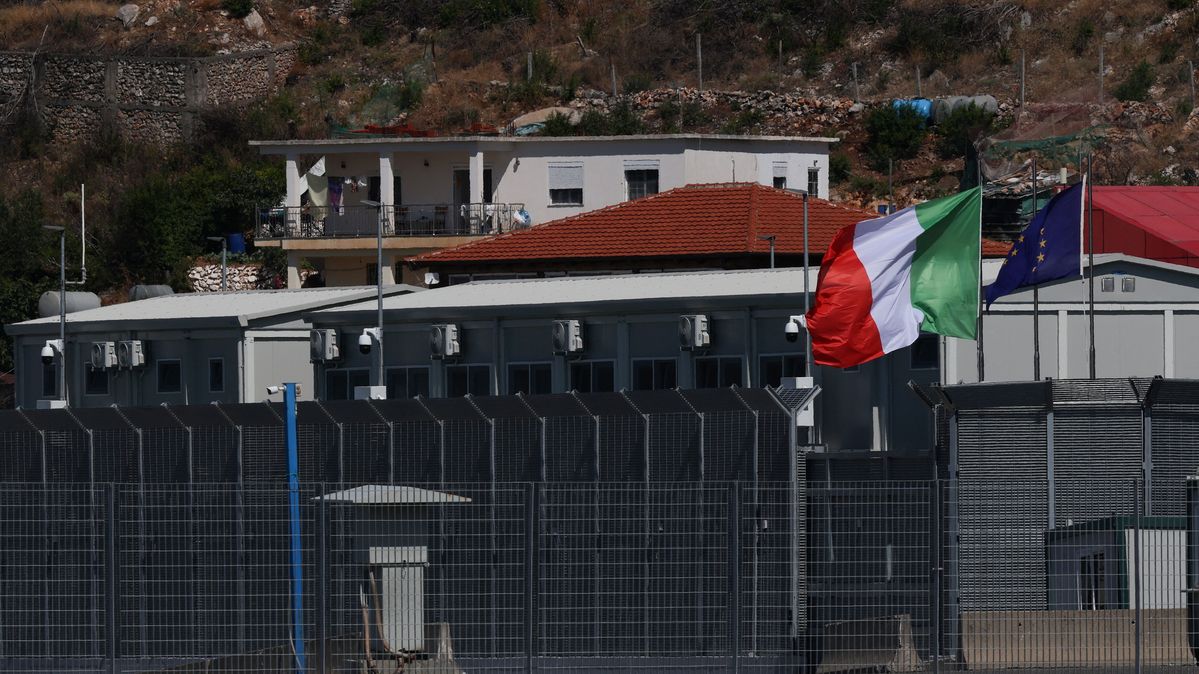 A reception camp in Shengjin, Albania, set up as part of an Italian government plan to process migrants rescued at sea Houses behind a high fence with an Italian flag