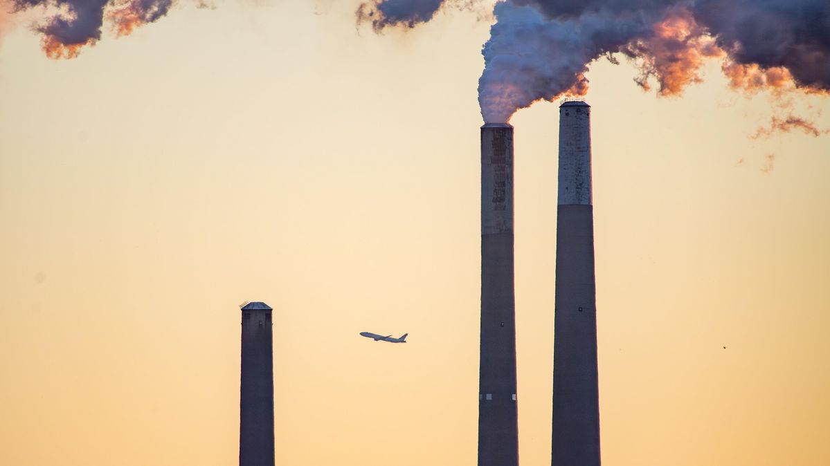A commercial aircraft passes steam and pollution from the Miami Fort Power Station in Lawrenceburg, Indiana. An airplane passes the steam from the chimneys of a power station.